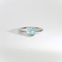 Halo silver ring with blue topaz in 18ct setting by Charmian Ottaway