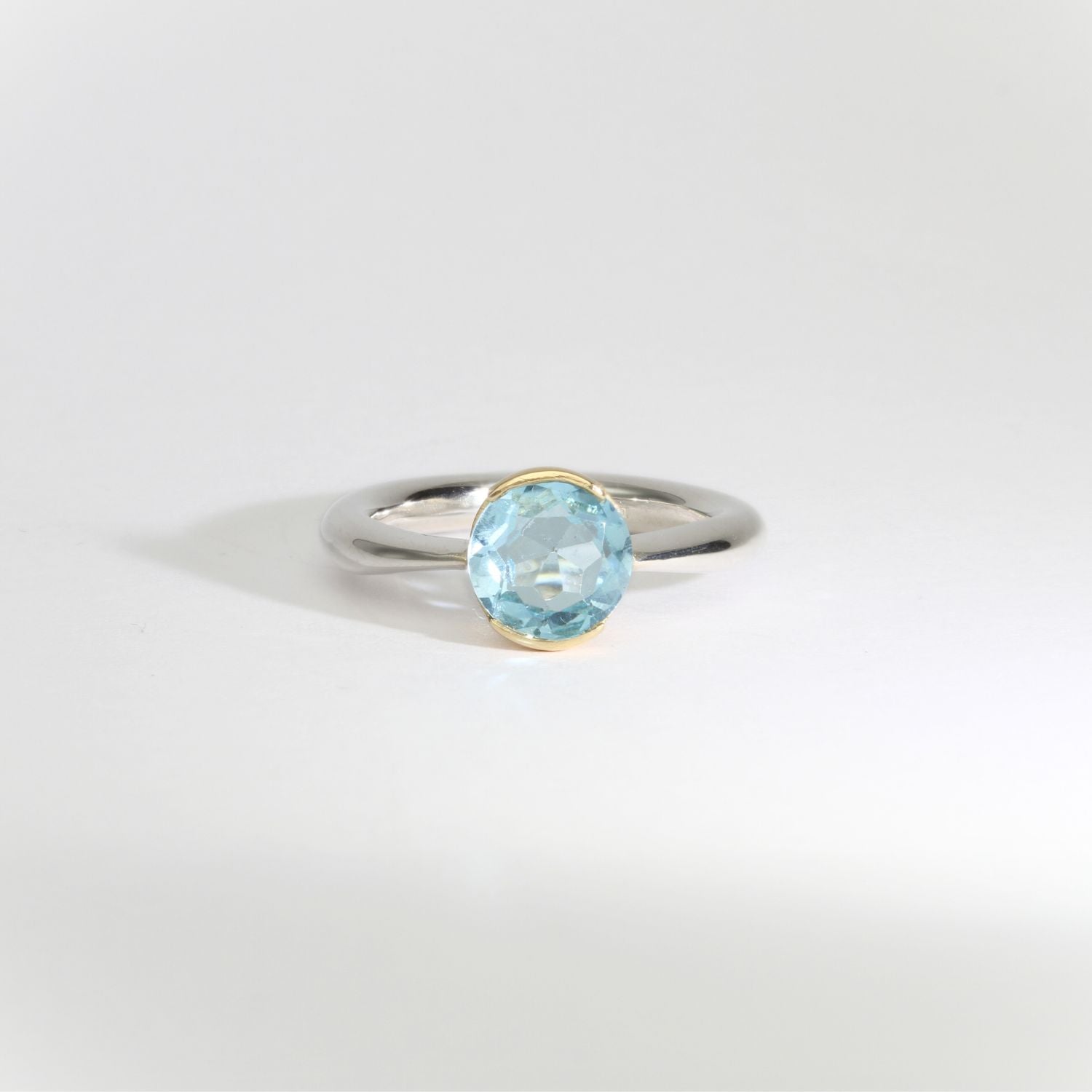 Halo silver ring with blue topaz in 18ct setting by Charmian Ottaway
