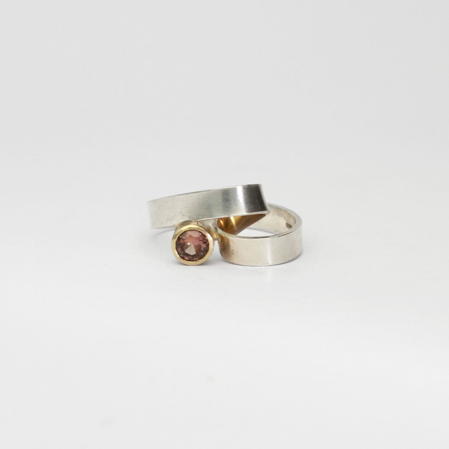 Silver ribbon loop ring with sapphire set in 9ct yellow gold by Jodie Hook