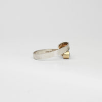 Silver ribbon loop ring with sapphire set in 9ct yellow gold by Jodie Hook