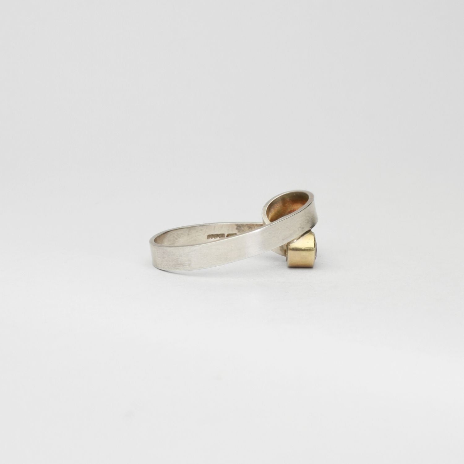Silver ribbon loop ring with sapphire set in 9ct yellow gold by Jodie Hook