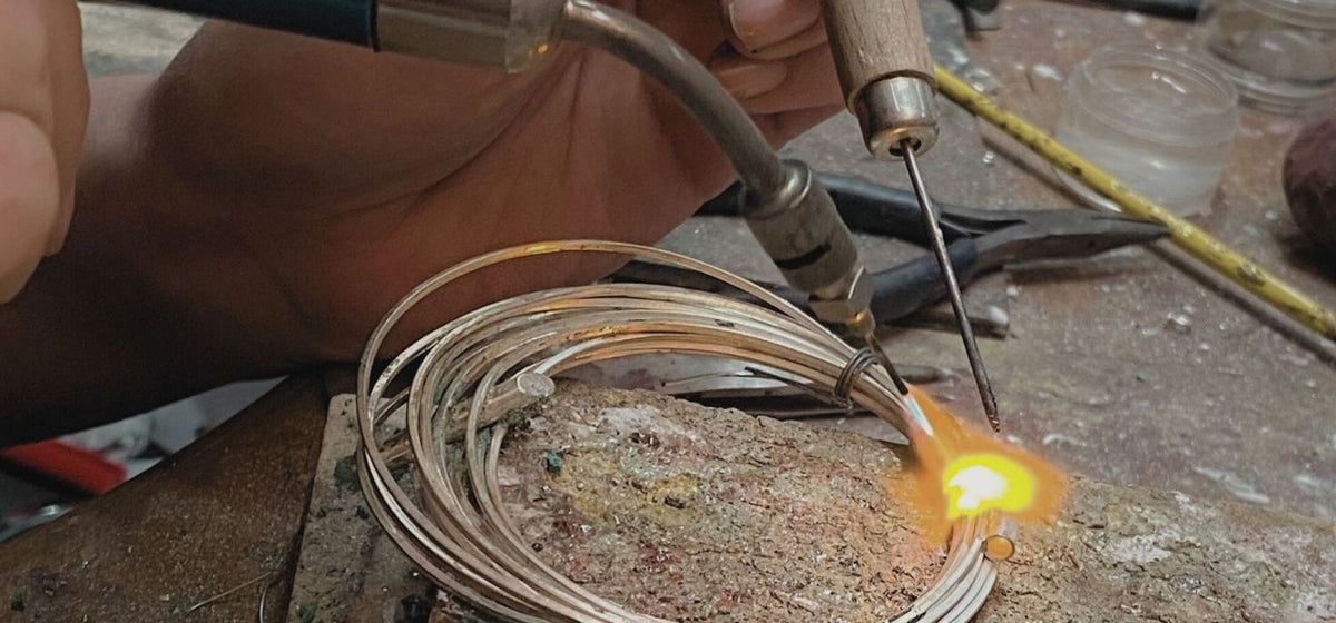 precious metal creating multi faceted polished surfaces hold a single faceted stone set at an angle where it catches the light or faces the wearer.