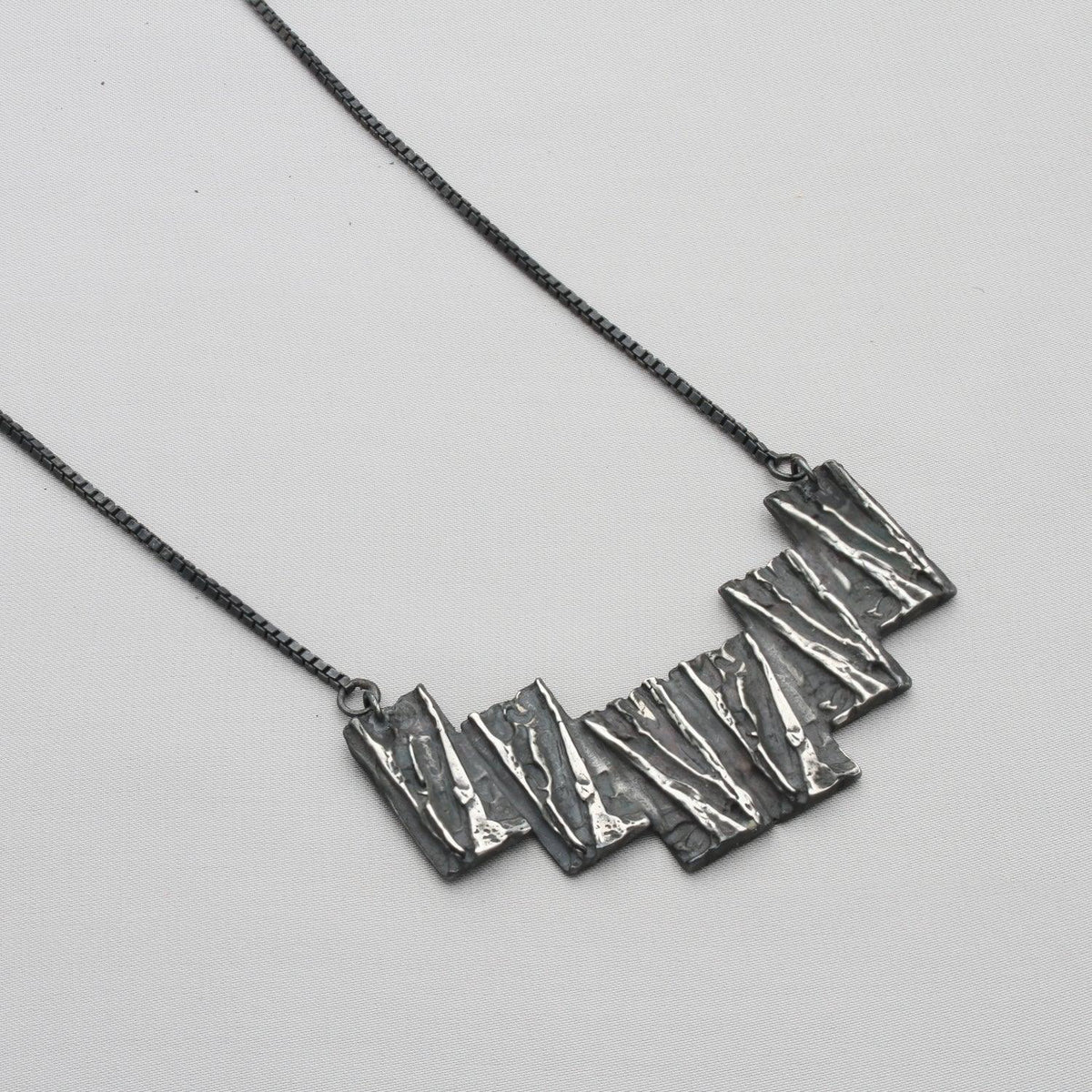 Contemporary Welsh silver jewellery. Inspired by the beautiful landscape of Wales especially slate and coal. This statement necklace is designed and handmade in Wales
