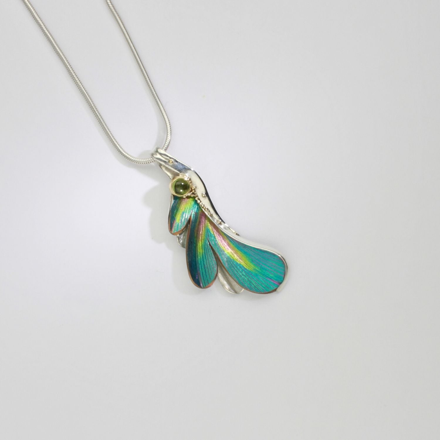 Pendant - poppy/daisy niobium, silver & 18ct gold pendant with peridot by Brian Eburah