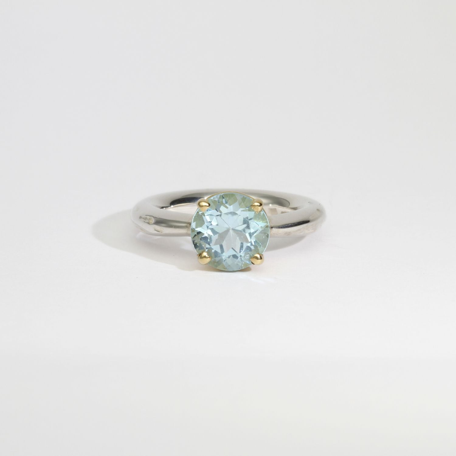 Halo silver ring with a round topaz in a 18ct setting by Charmian Ottaway