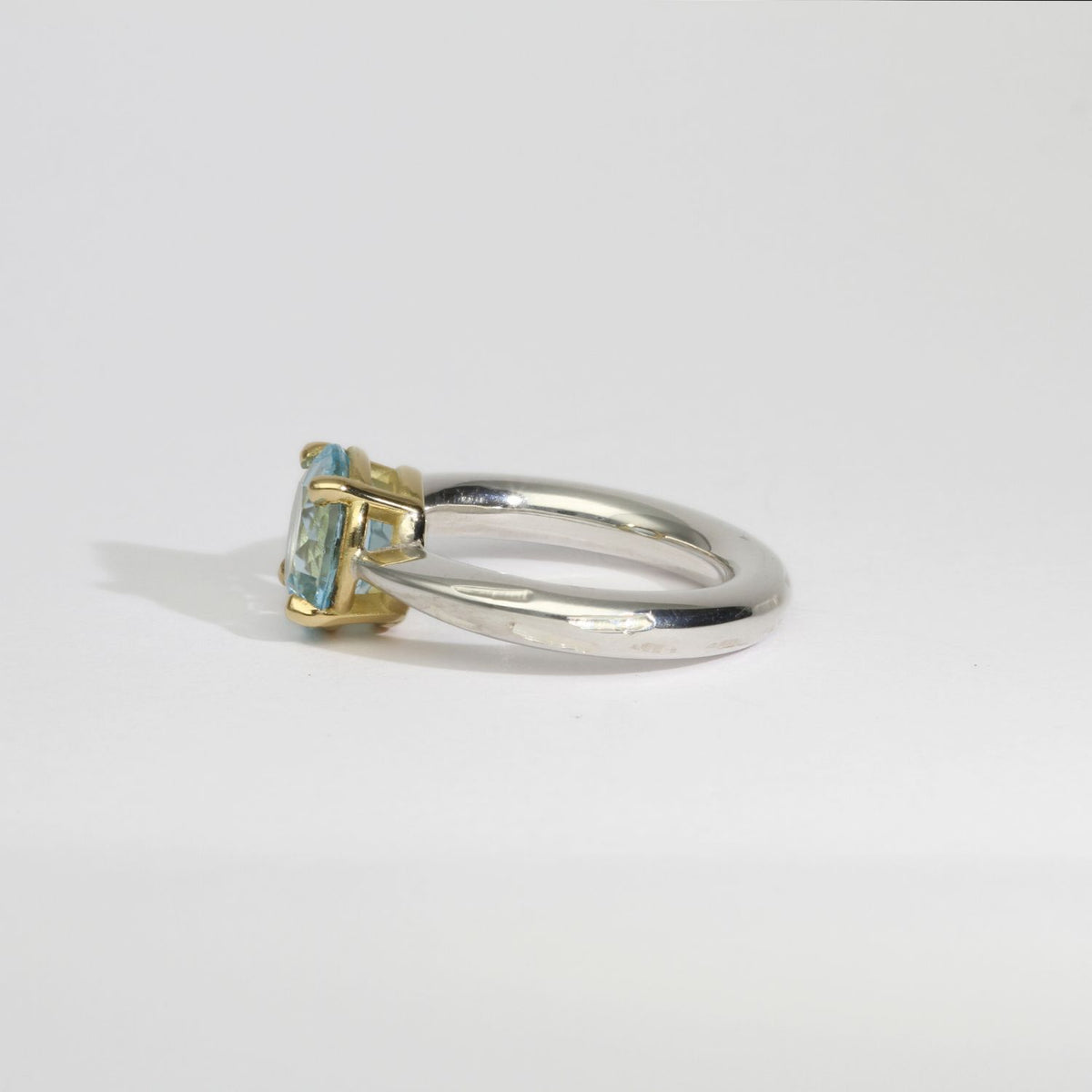 Halo silver ring with a round topaz in a 18ct setting by Charmian Ottaway