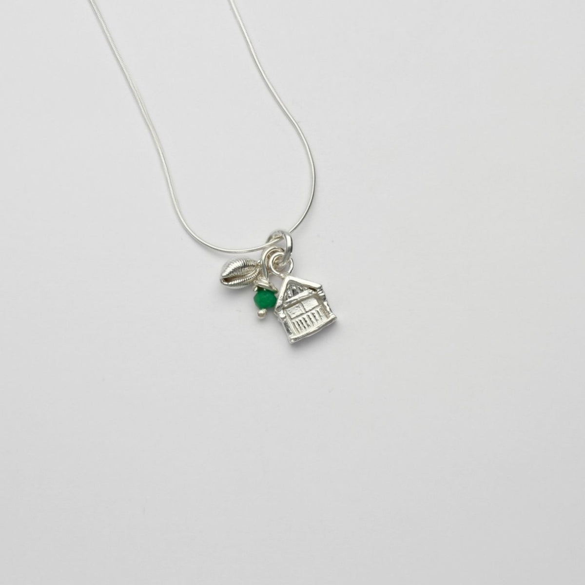 Beach hut with cowrie silver pendant with emerald bead by Emily Craig
