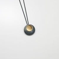 Small pebble black silver & gold plated pendant by Hannah Souter