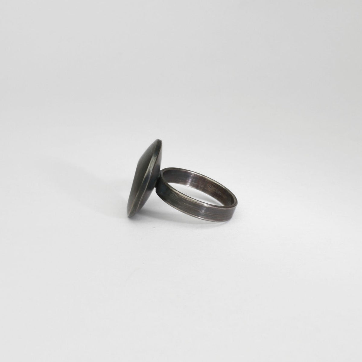Small pebble black silver & gold plated ring by Hannah Souter
