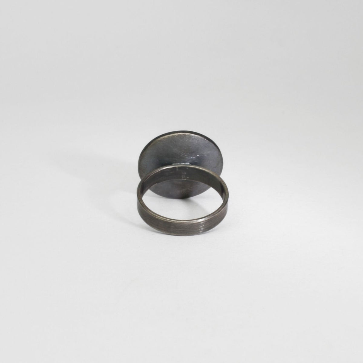 Small pebble black silver & gold plated ring by Hannah Souter