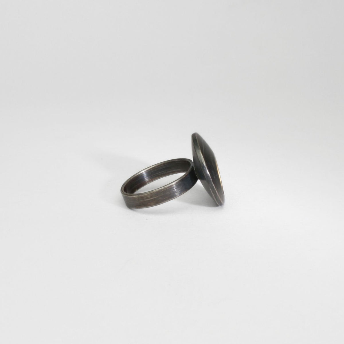 Small pebble black silver & gold plated ring by Hannah Souter