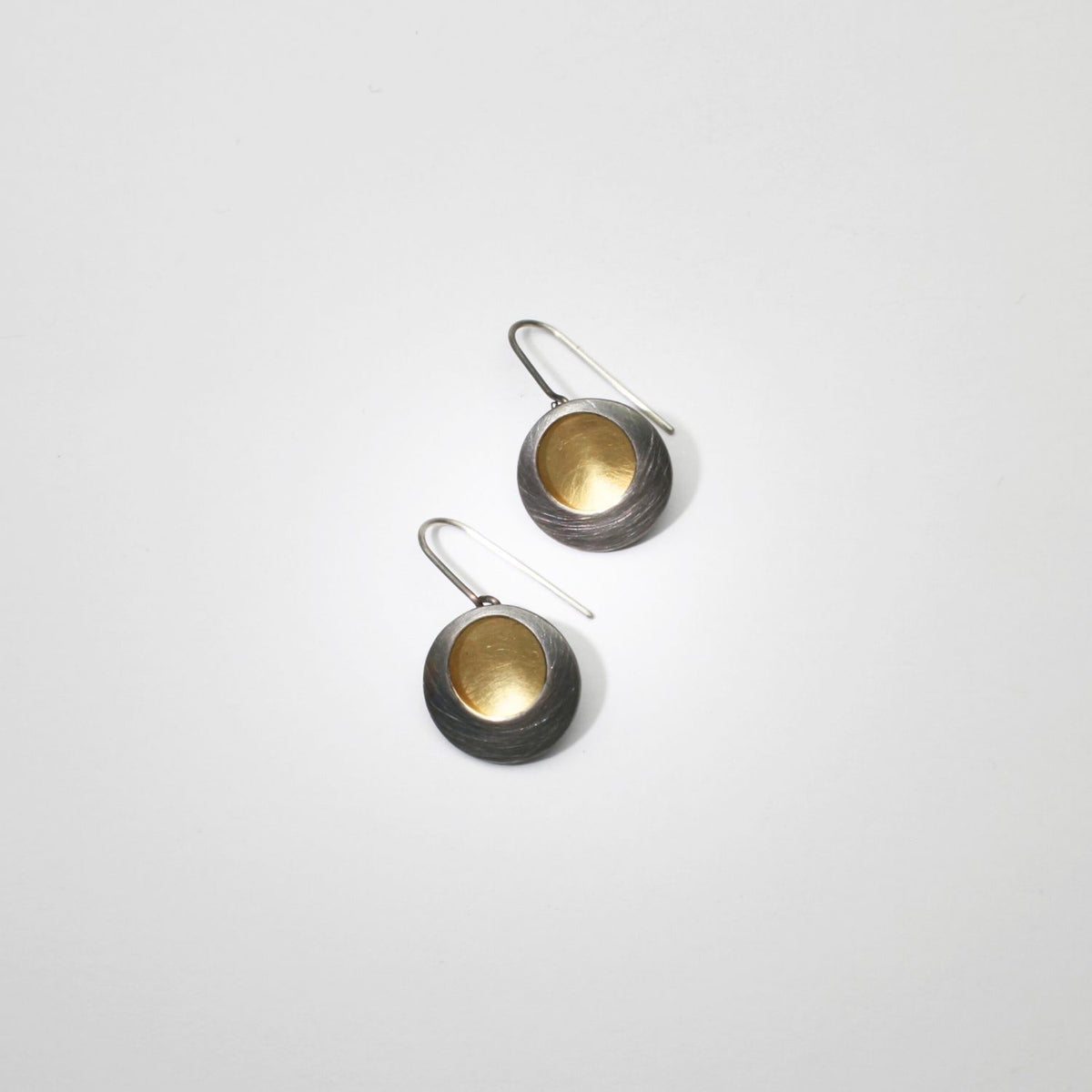 Pebble satin black silver & gold plated drop earrings by Hannah Souter