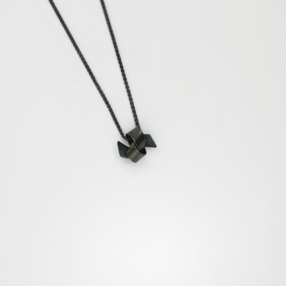 Small ribbon knot tied black silver pendant by Jodie Hook
