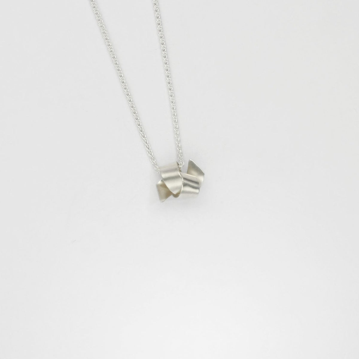 Small ribbon knot tied silver pendant by Jodie Hook