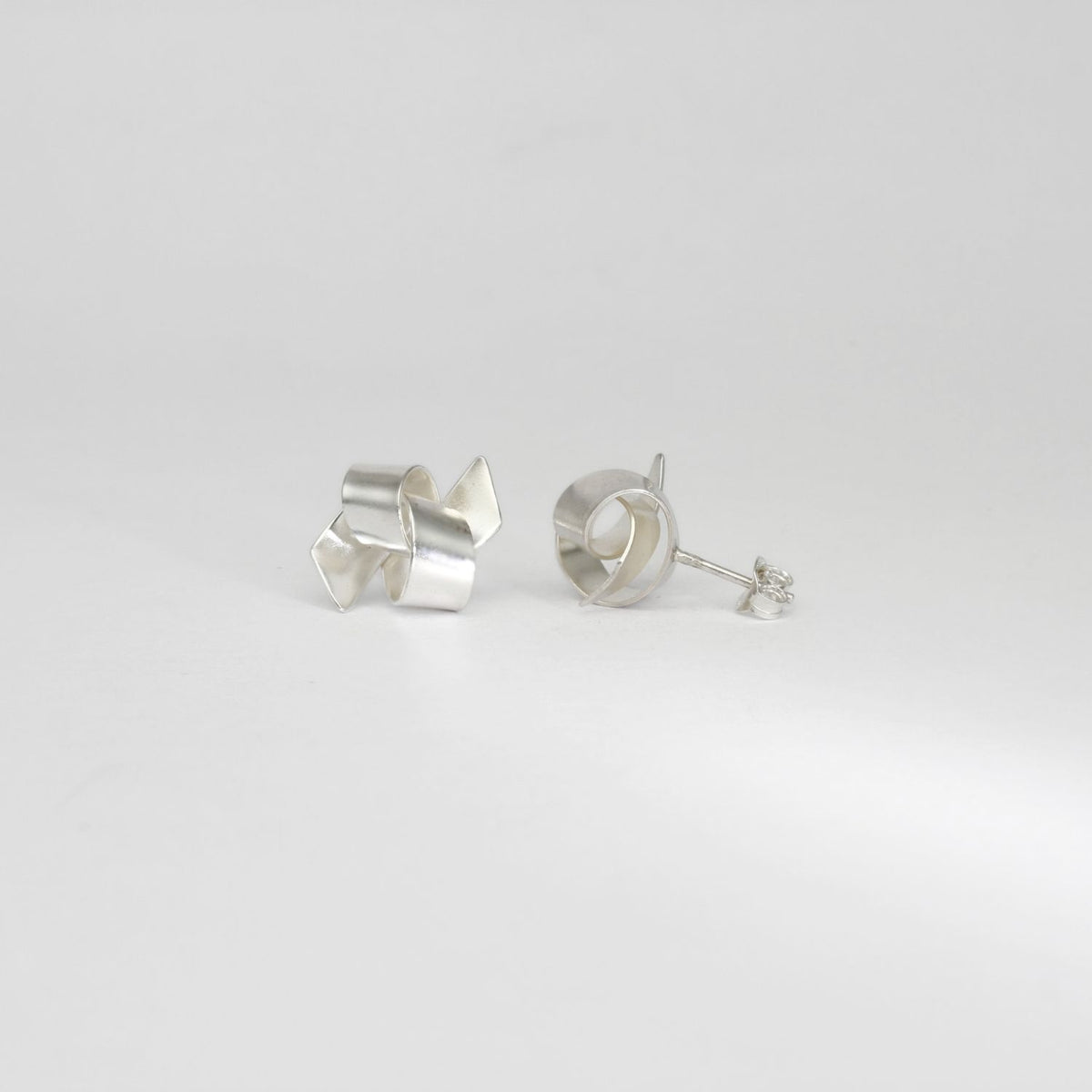Ribbon knot tied silver stud earrings by Jodie Hook