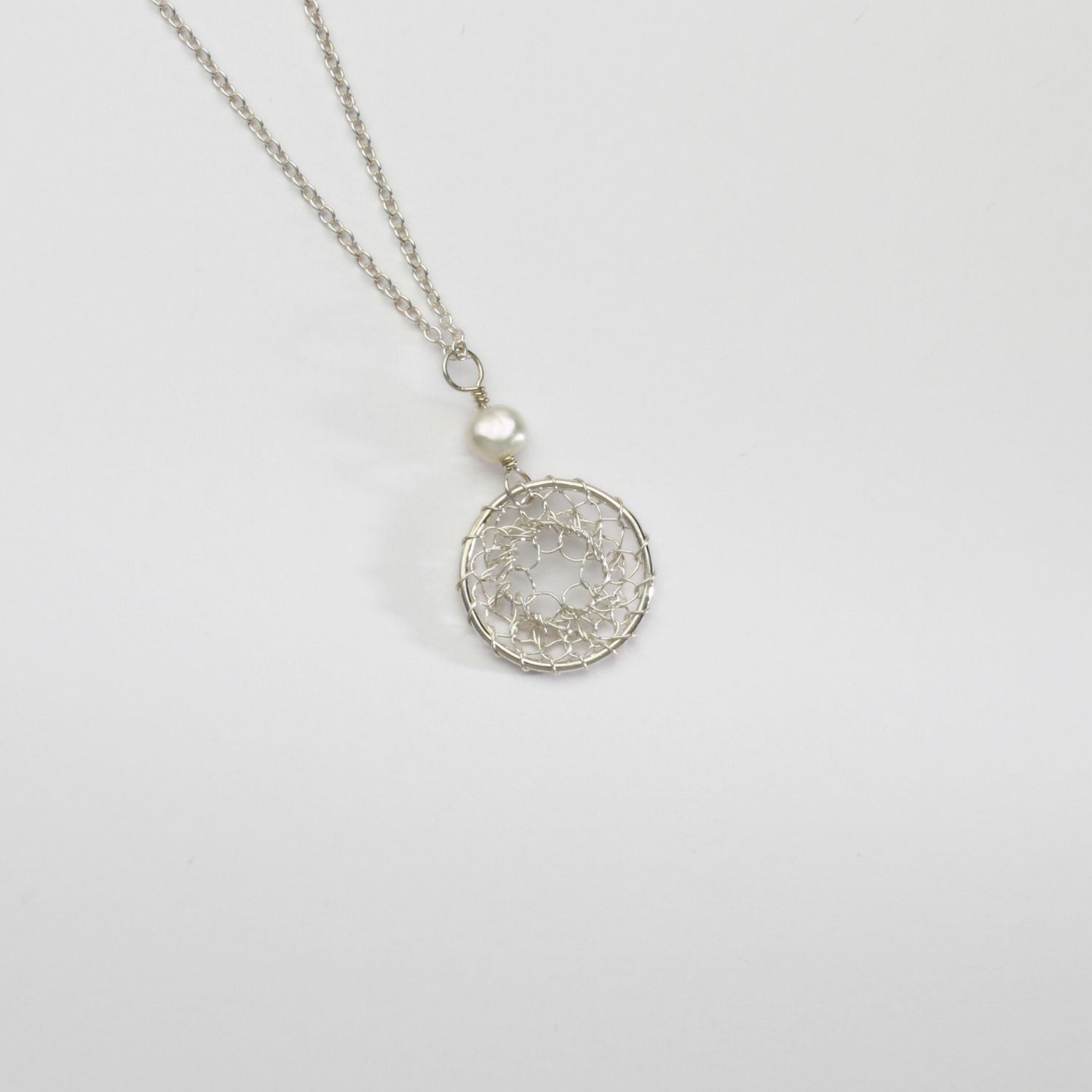 Lace circle with white pearl silver pendant by Natalie Vardey