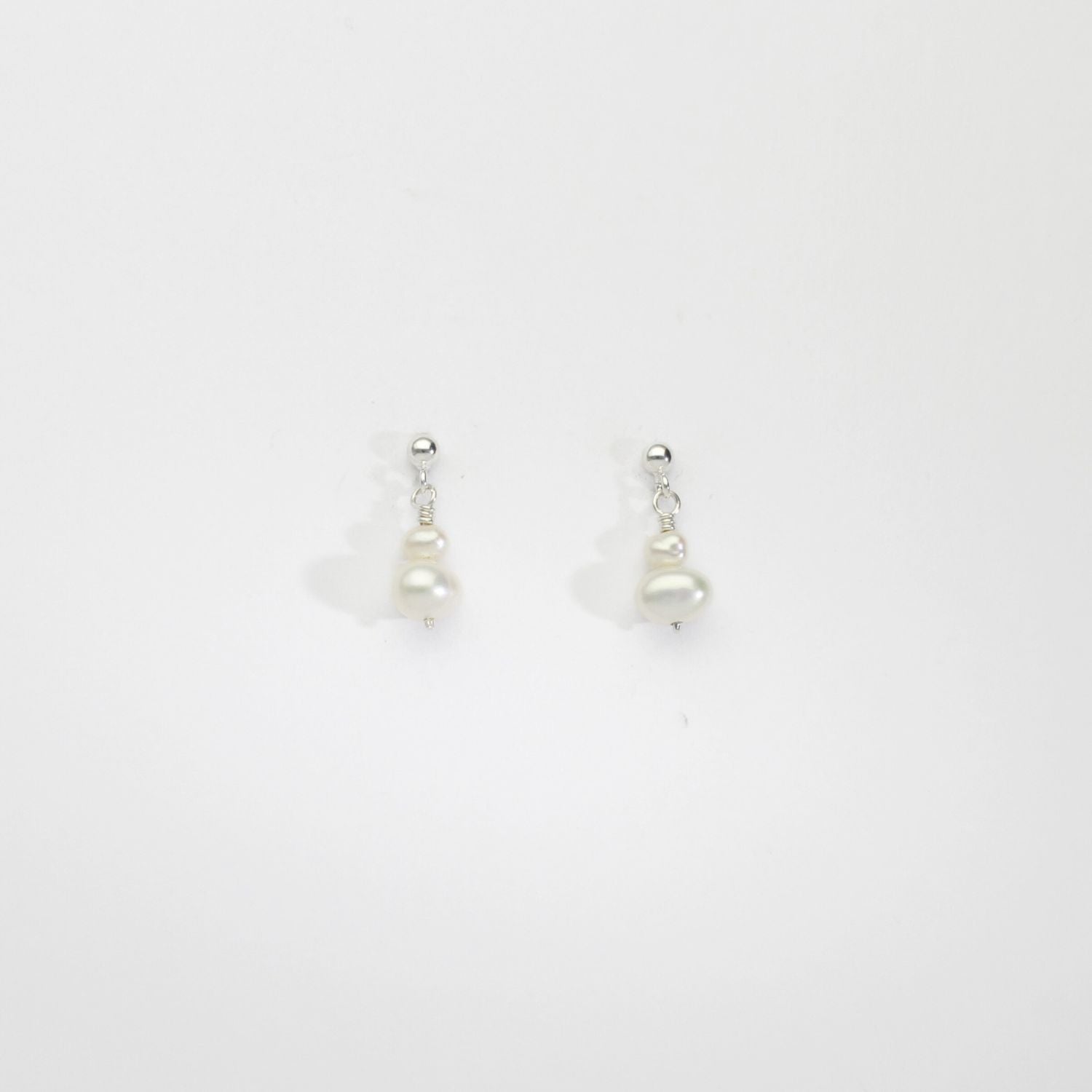 Small white squab & wee white pearl silver stud earrings by Natalie Vardey