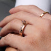 Welsh gold ring inspired by the strata of Welsh slate handcrafted and handmade in 18ct rose red gold. shown worn on model next to rose gold ding set with diamonds and pink morganite stone