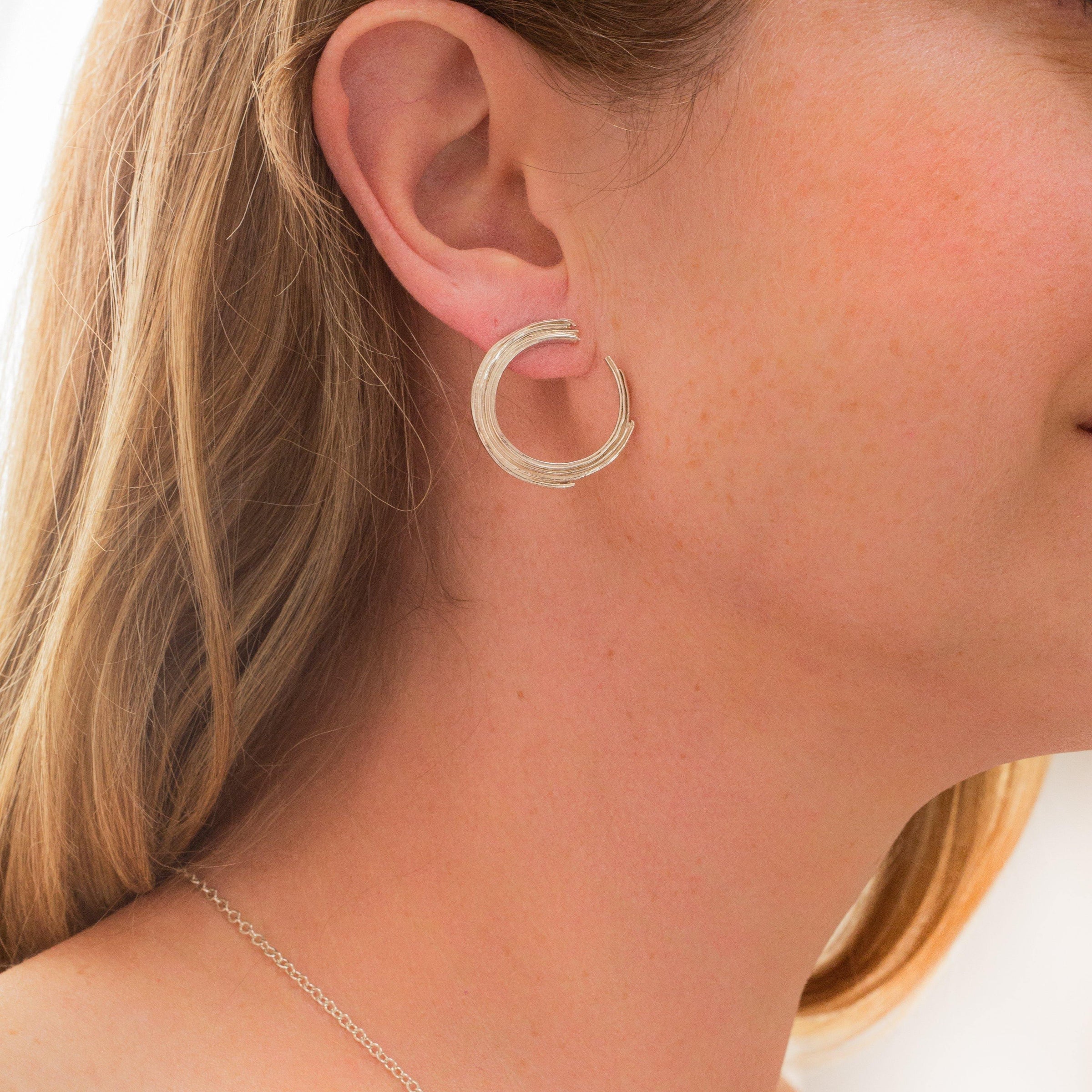 Close-up of the sweeping line on a Brushstroke full arc earring — Clustdlysau Arian