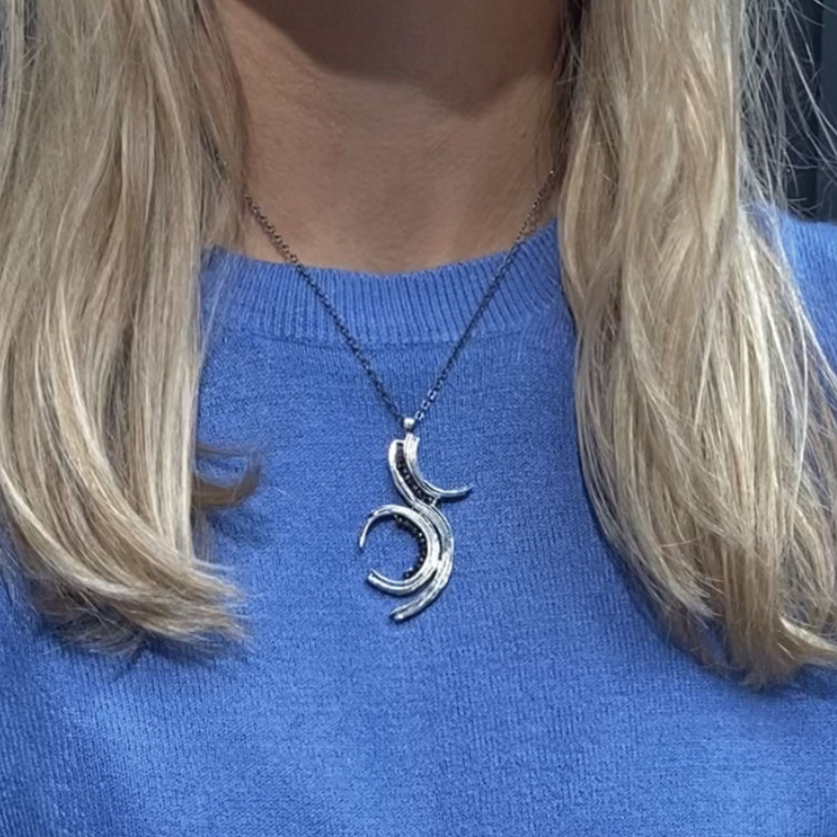 Brushstroke pendant in black oxidised silver with black diamonds, shown on model