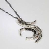 Brushstroke pendant in black oxidised silver with black diamonds, styled