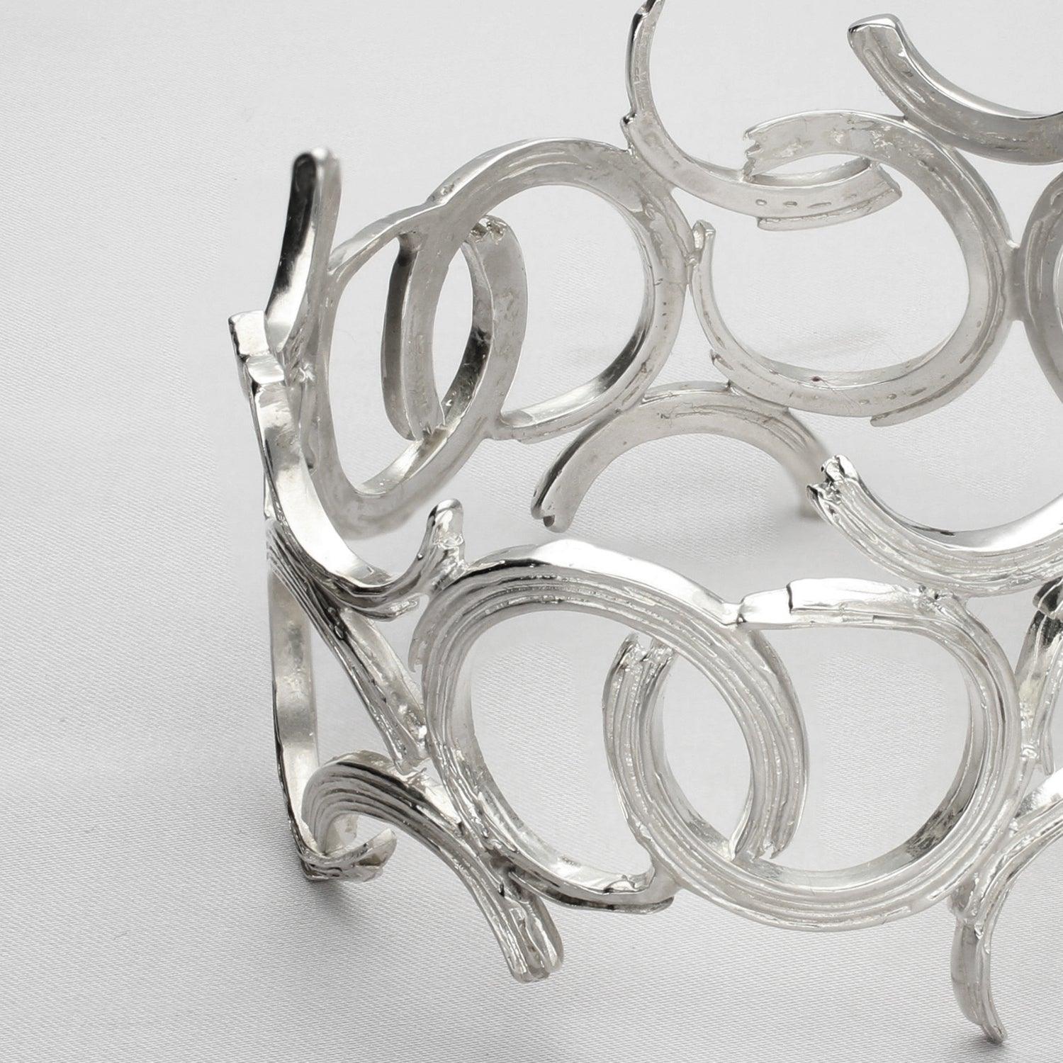 Close-up on the fluid line of the Brushstroke bangle, echoing an artist's gesture — Breichled Arian