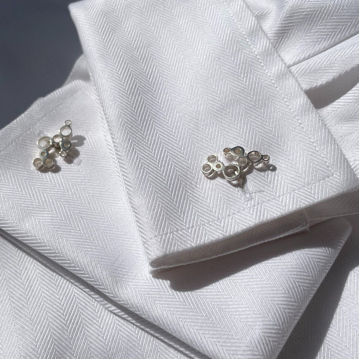 Bubbles cufflinks fastened on a shirt cuff, celebration-inspired design — Botymau Coesau Arian
