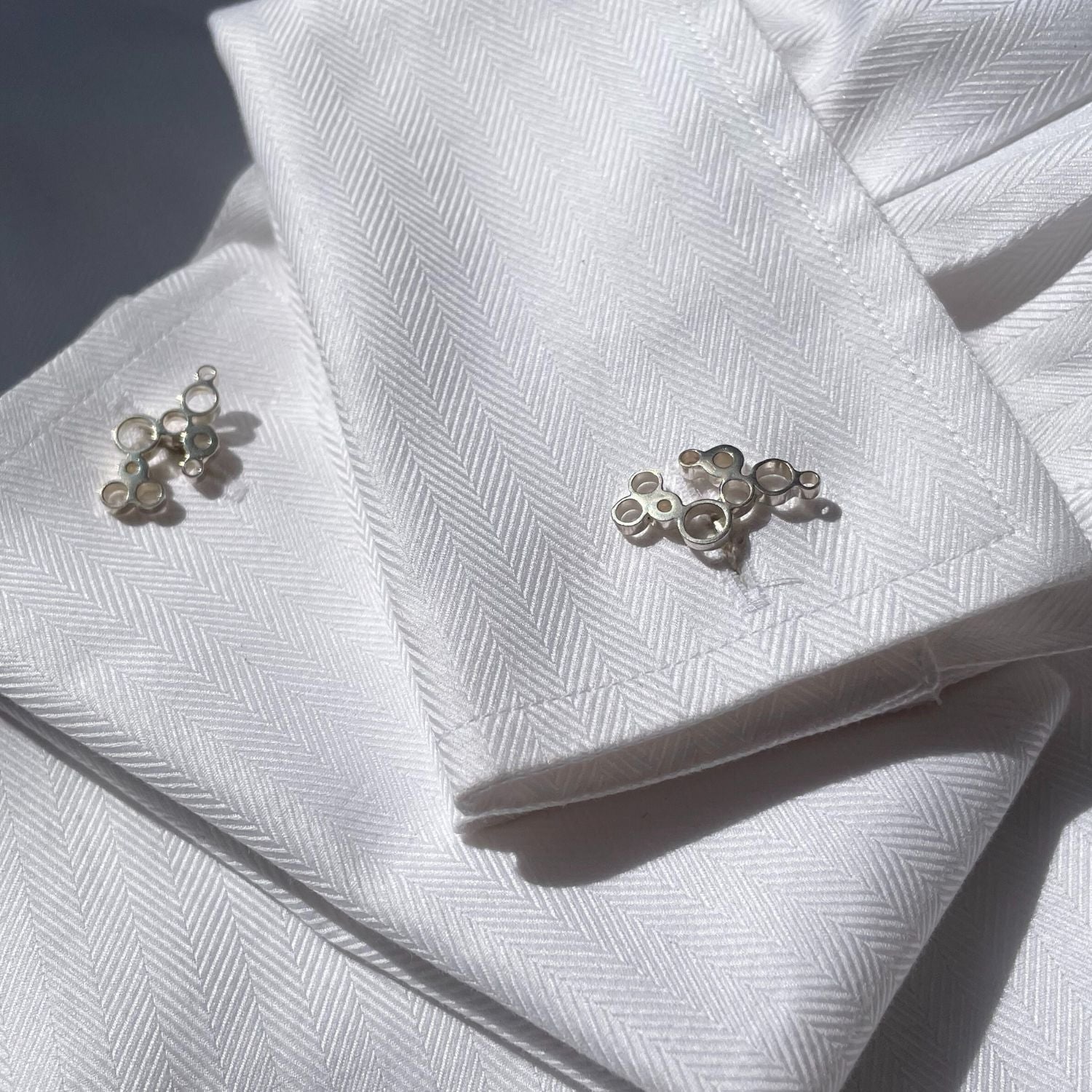 Bubbles cufflinks fastened on a shirt cuff, celebration-inspired design — Botymau Coesau Arian