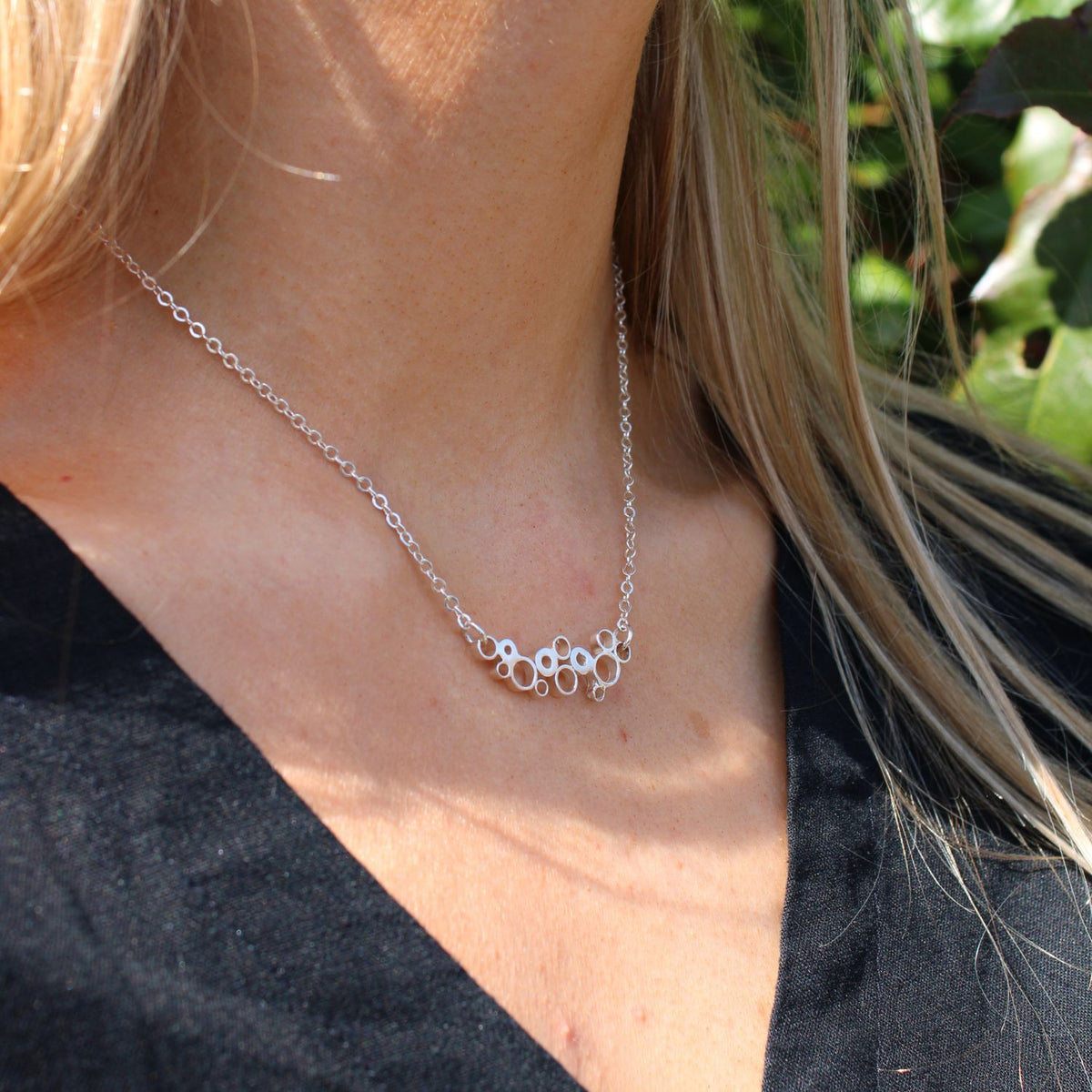 Bubbles sterling silver curved pendant, shown on model