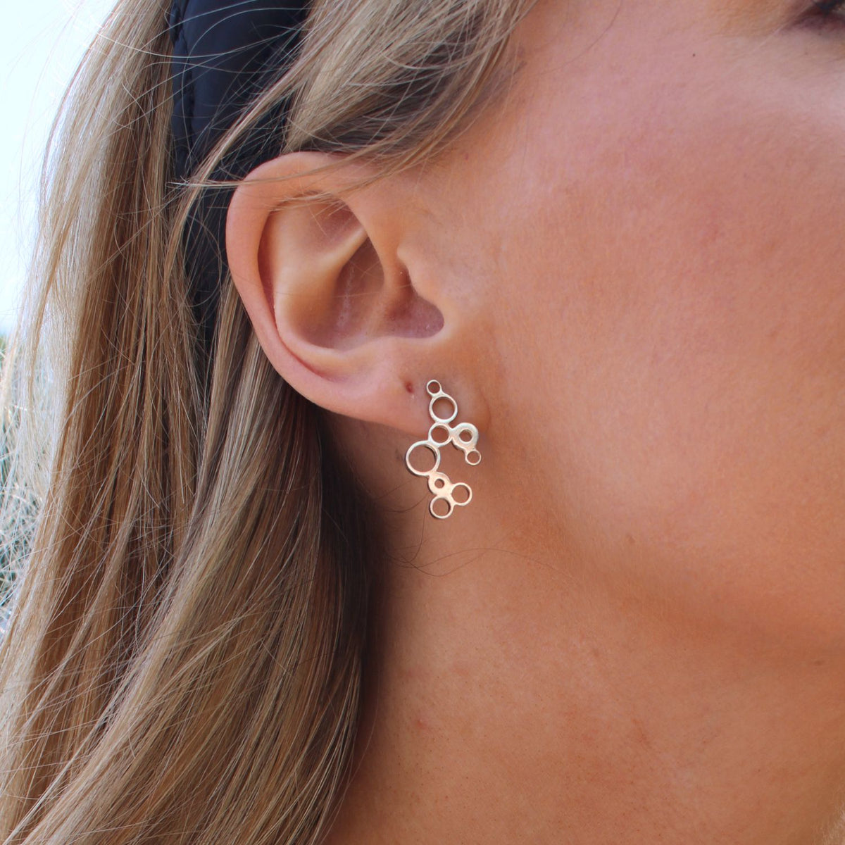 Model wearing the Bubbles earrings, celebration-inspired design — Clustdlysau Arian