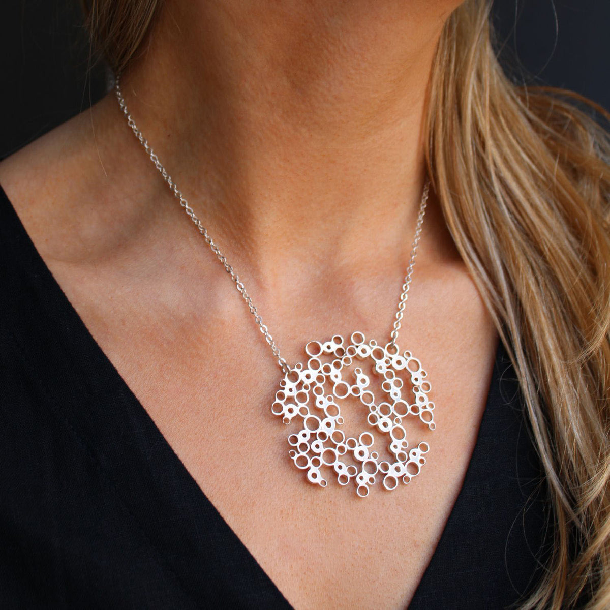Model wearing the Bubbles large pendant, celebration-inspired design — Mwclis Arian
