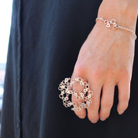Model wearing the Bubbles large ring alongside the charm bracelet, effervescent design — Modrwy Arian
