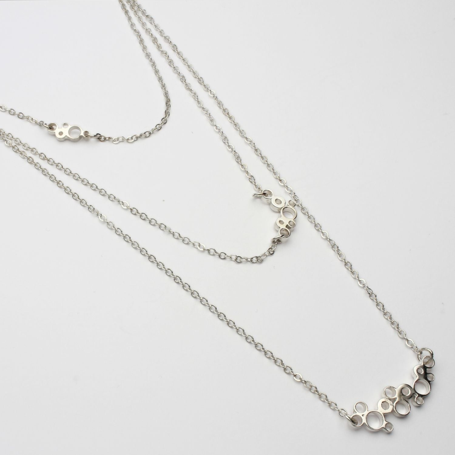 Close-up on the Bubbles layered necklace's clustered circles, echoing bubbles in a glass — Mwclis Arian