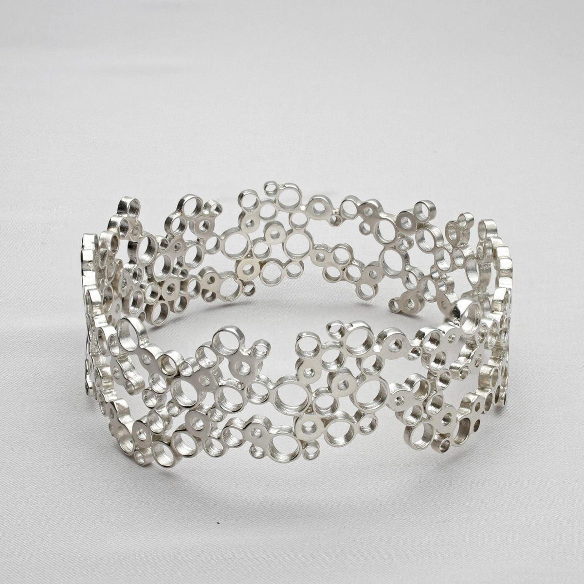Bubbles bangle, sterling silver — clustered circles inspired by rising champagne bubbles, front view — Breichled Arian
