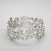Bubbles bangle, sterling silver — clustered circles inspired by rising champagne bubbles, front view — Breichled Arian