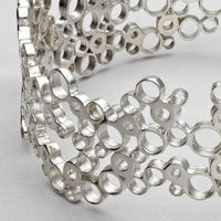Close view of the clustered circles forming the Bubbles bangle, echoing bubbles in a glass — Breichled Arian
