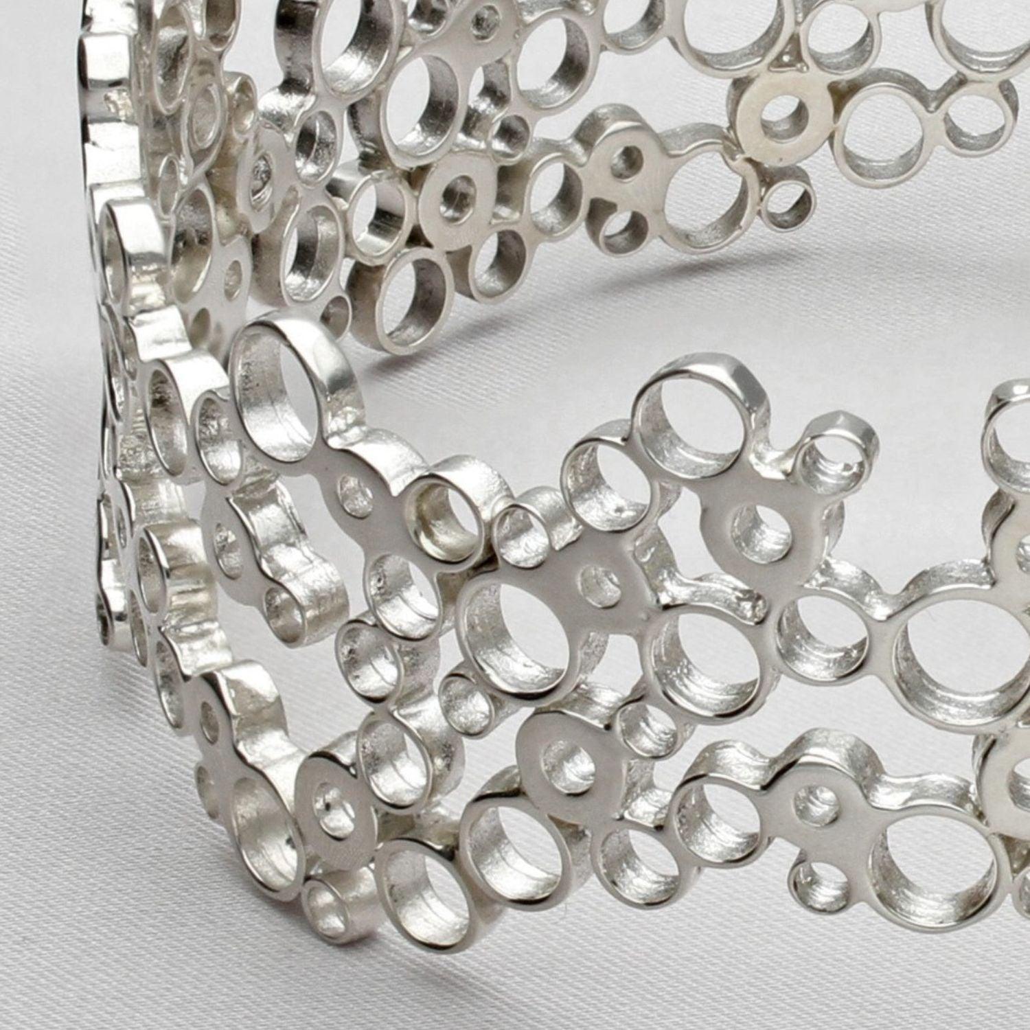 Close view of the clustered circles forming the Bubbles bangle, echoing bubbles in a glass — Breichled Arian
