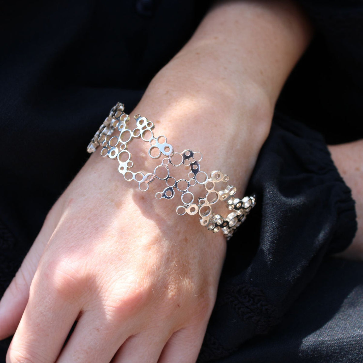 Model wearing the Bubbles bangle, front angle, celebration-themed — Breichled Arian