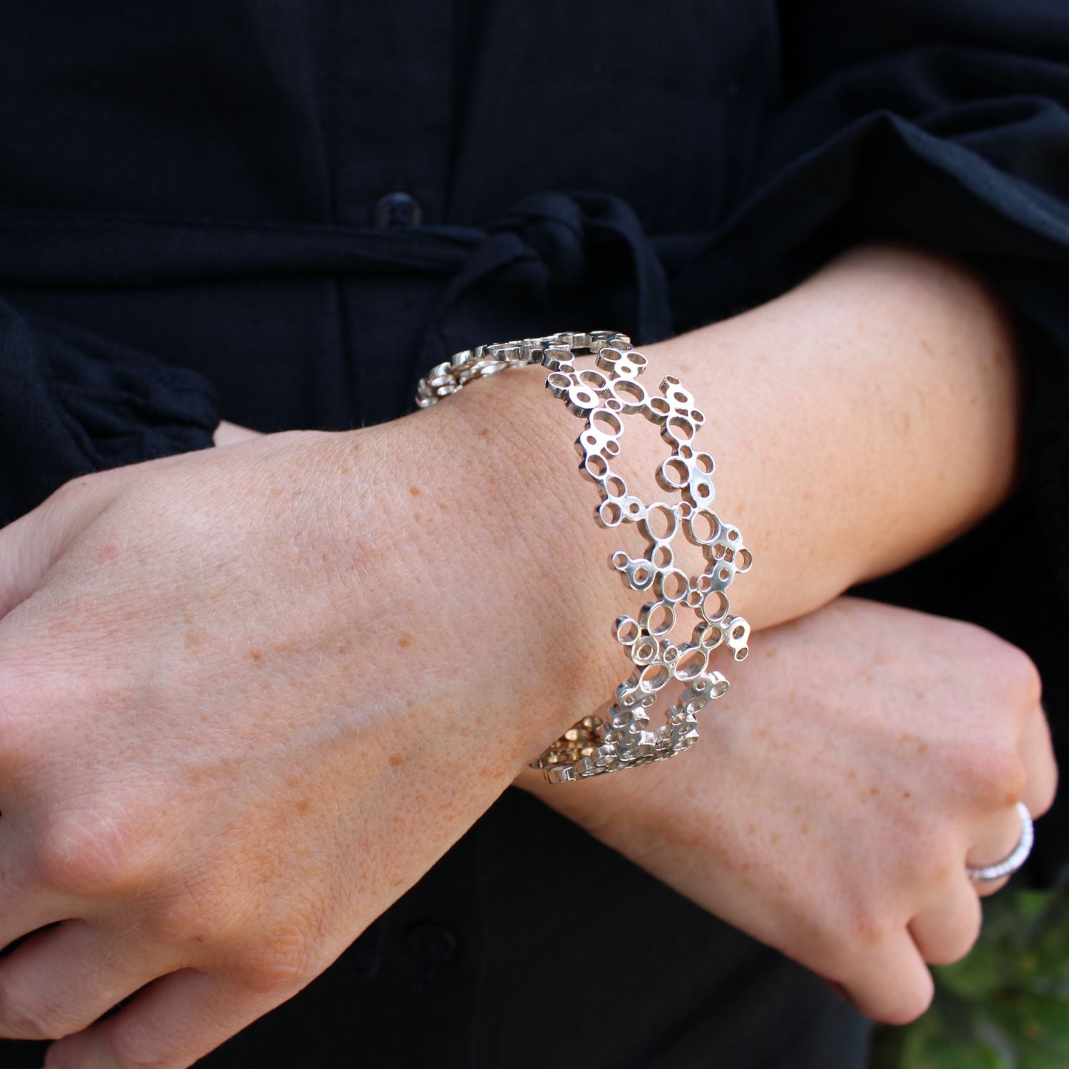 Model wearing the Bubbles bangle, side angle, effervescent design — Breichled Arian