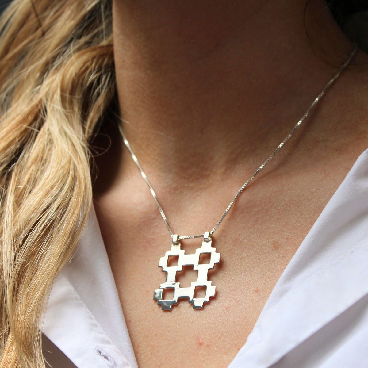 Model wearing the Caernarfon hatch medium pendant, carrying the memory of home — Mwclis Arian