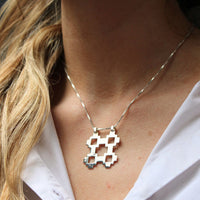 Model wearing the Caernarfon hatch medium pendant, carrying the memory of home — Mwclis Arian