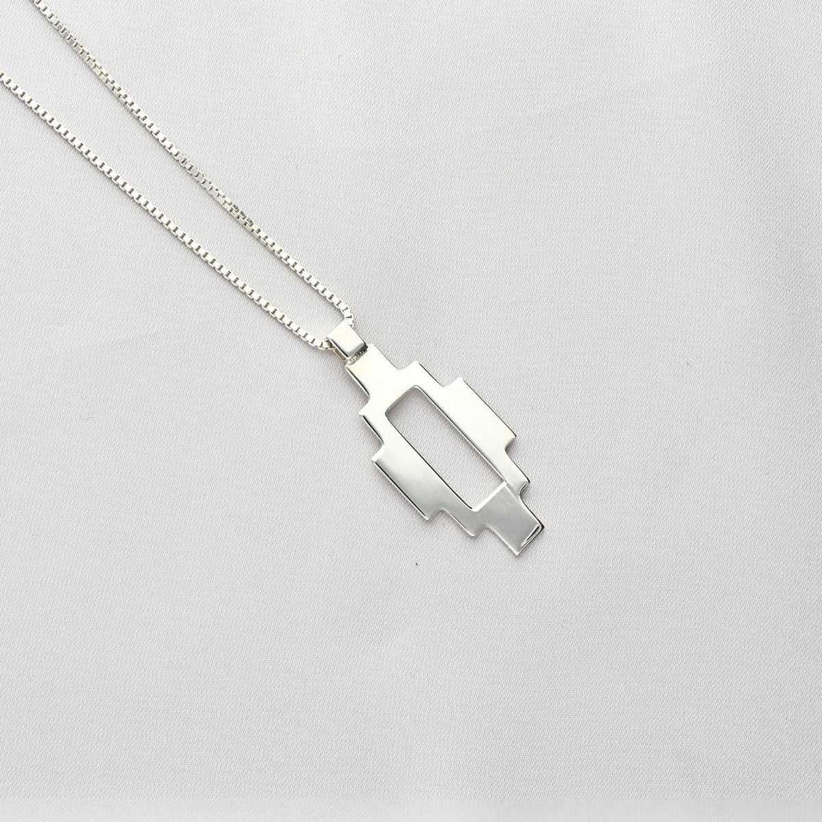 Caernarfon long pendant, sterling silver — the Welsh weave stretched into a linear form — Mwclis Arian