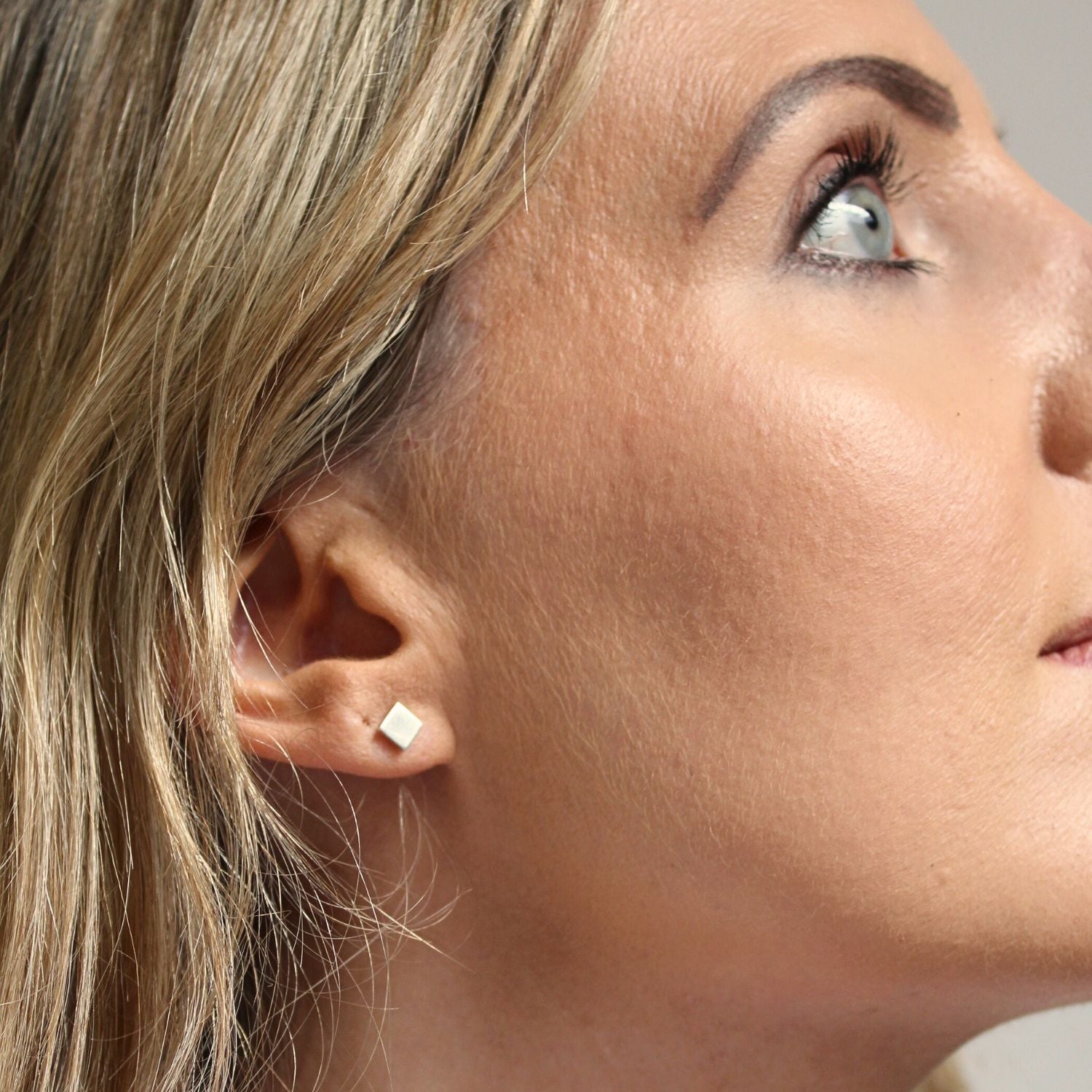 Model wearing the Carthenni earrings, carrying a fragment of the carthen pattern — Clustdlysau Arian