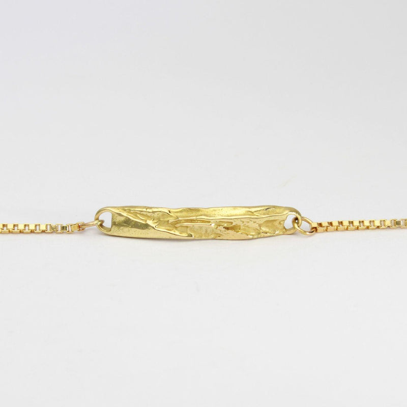 Close detail of contemporary Welsh gold jewellery designed and made in Wales and inspired by the Welsh landscape. the bracelet is handcarved in 18ct yellow gold 