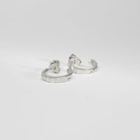 Carved sterling silver hoop earrings, side view showing texture