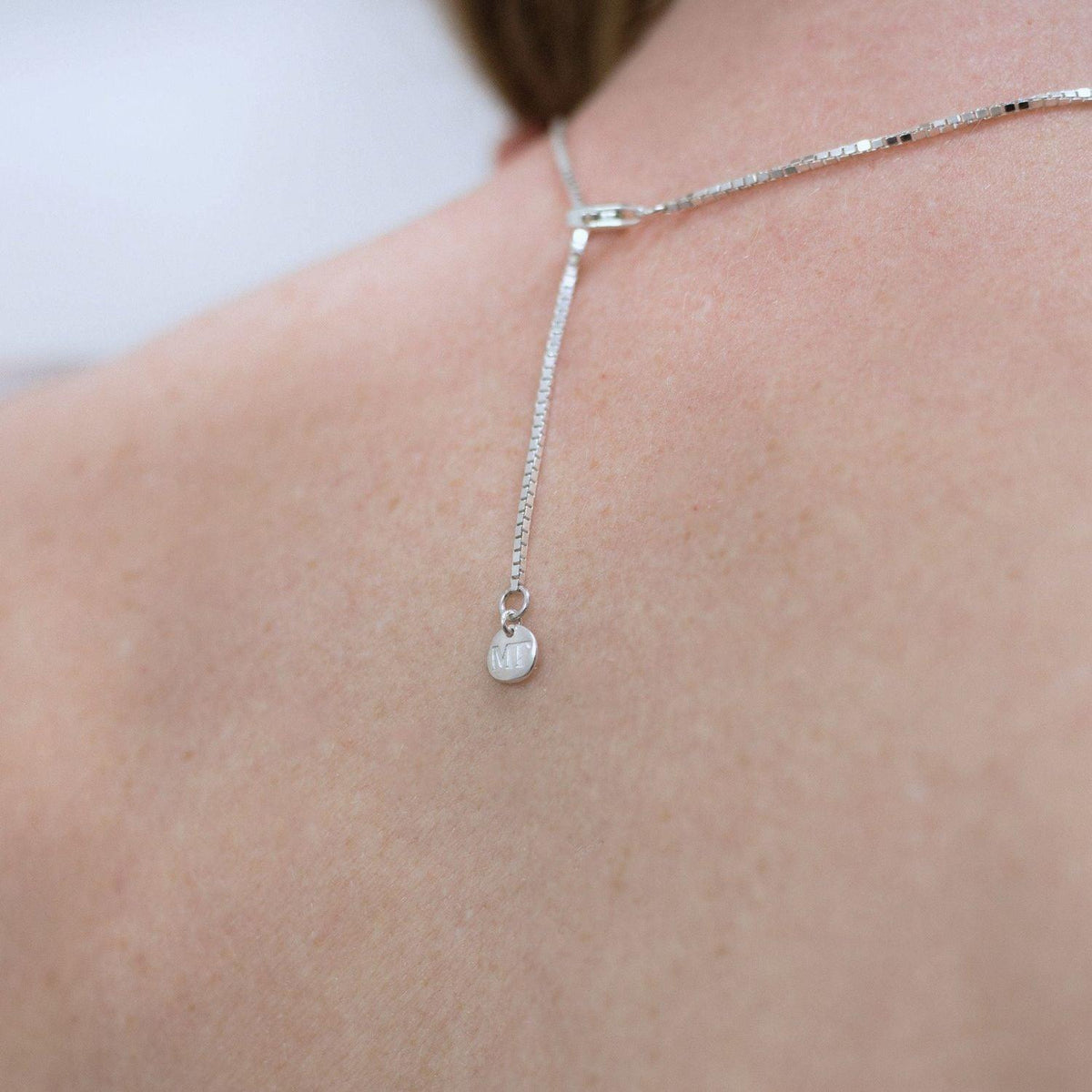 Chain detail showing MT tag in silver of award winning jeweler Mari Thomas maker of contemporary Welsh silver jewelry. Inspired by the beautiful landscape of Wales 