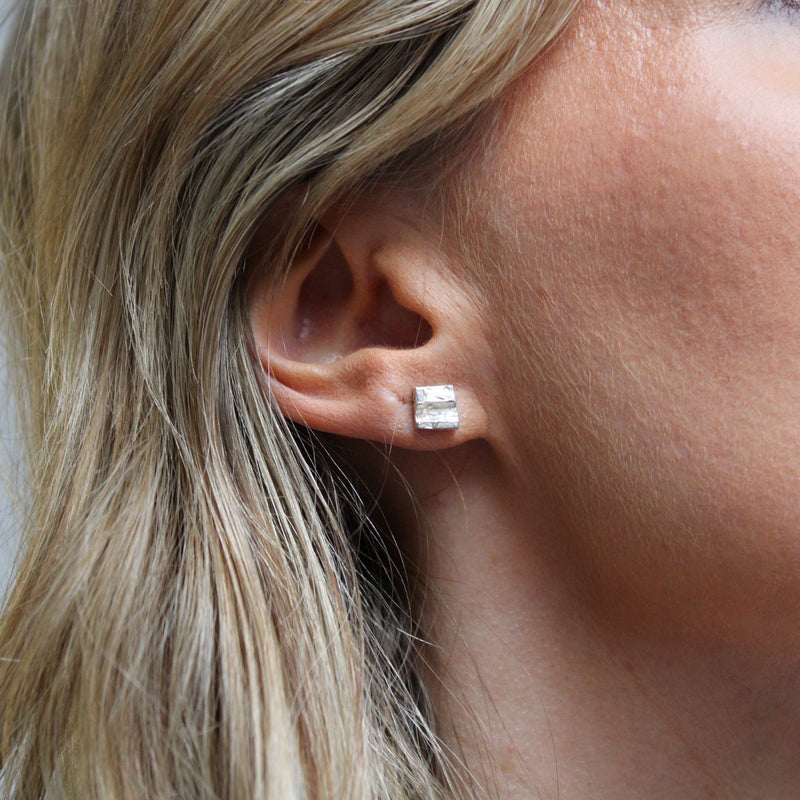 Contemporary Welsh silver jewellery. Inspired by the beautiful landscape of Wales.  These small textured square stud earrings shown on model are designed and handmade in Wales