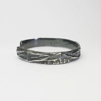 Contemporary Welsh silver jewellery. Inspired by the beautiful landscape of Wales especially slate and coal. This torque cuff bangle is designed and handmade in Wales. Suitable for men or women. Side view