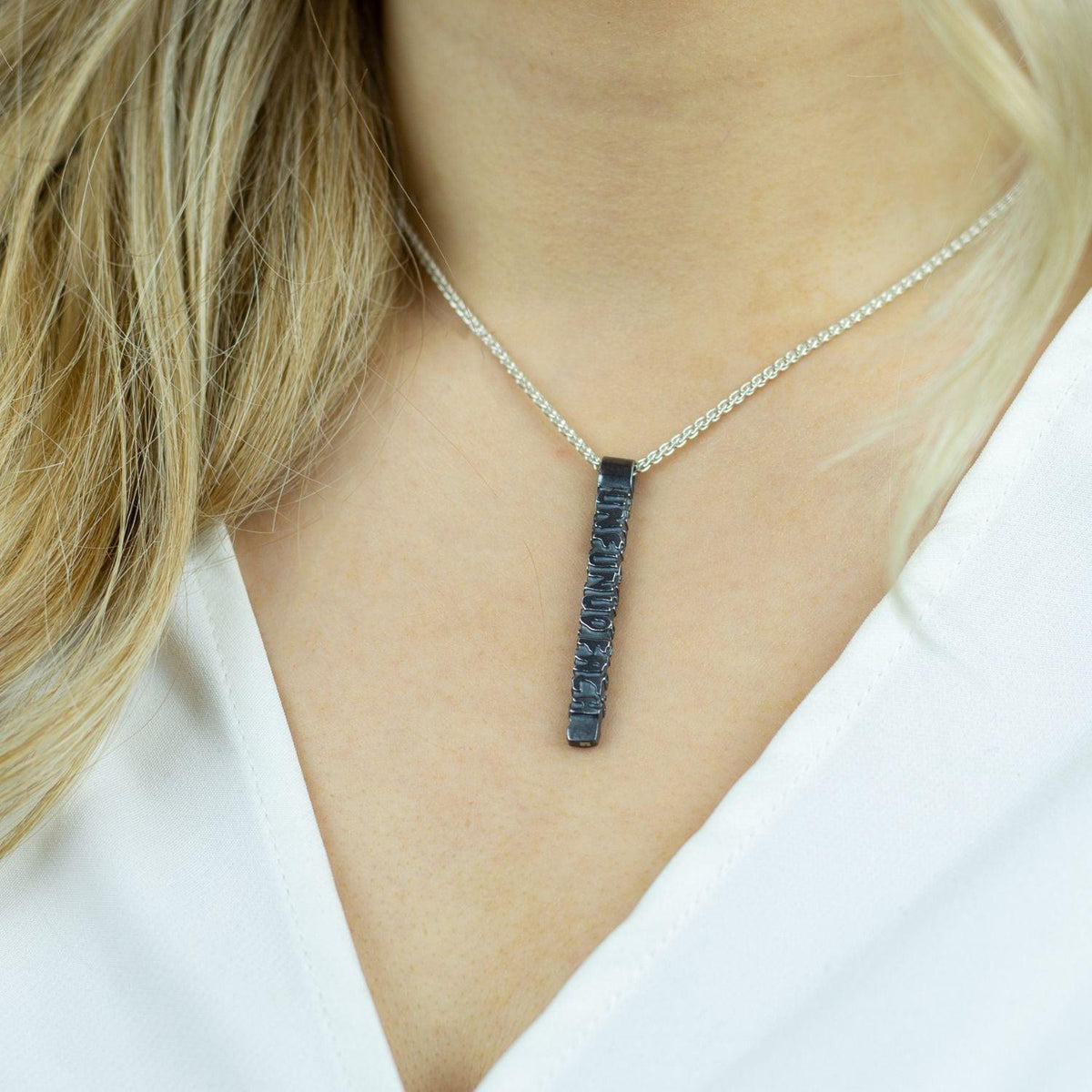 Side view of the Cofio black pendant, tracing a verse of remembrance — Mwclis Arian