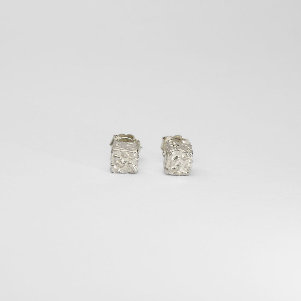 Cube stud earrings, sterling silver — covered in fragments of Mari's own handwriting — Clustdlysau Arian